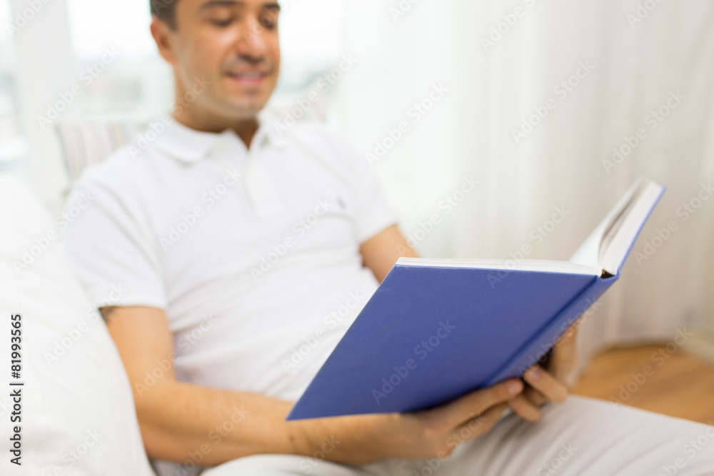 close up of happy man reading book at home close up of happy man reading book at home
