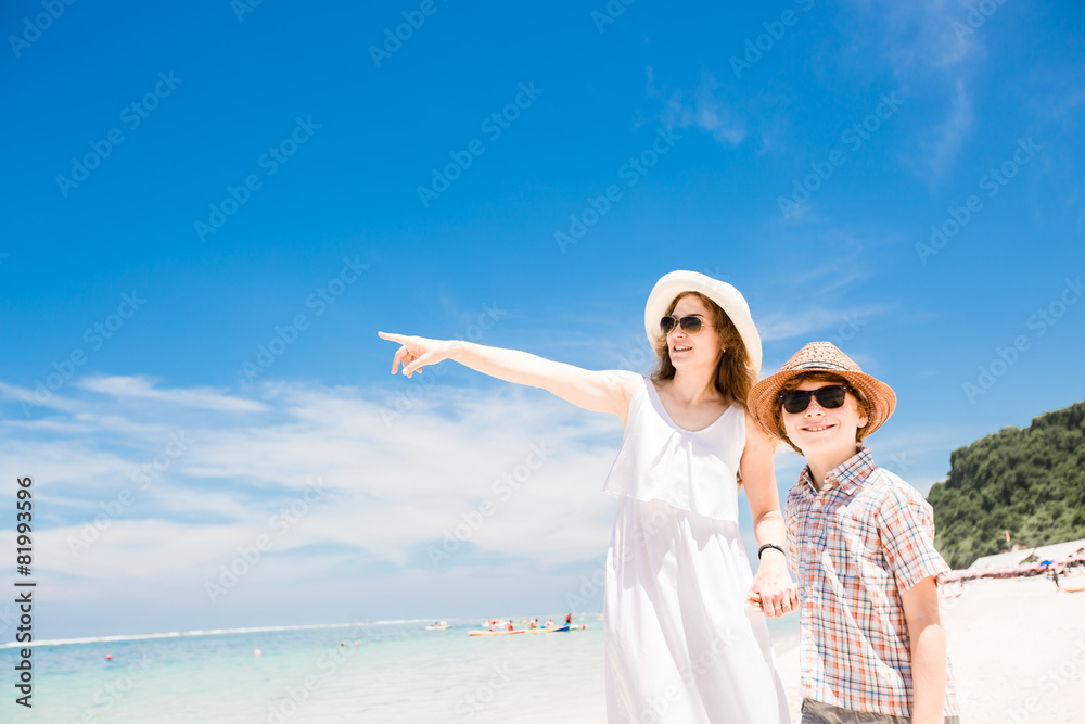 Happy beautiful young mother and son enjoying beach time with
