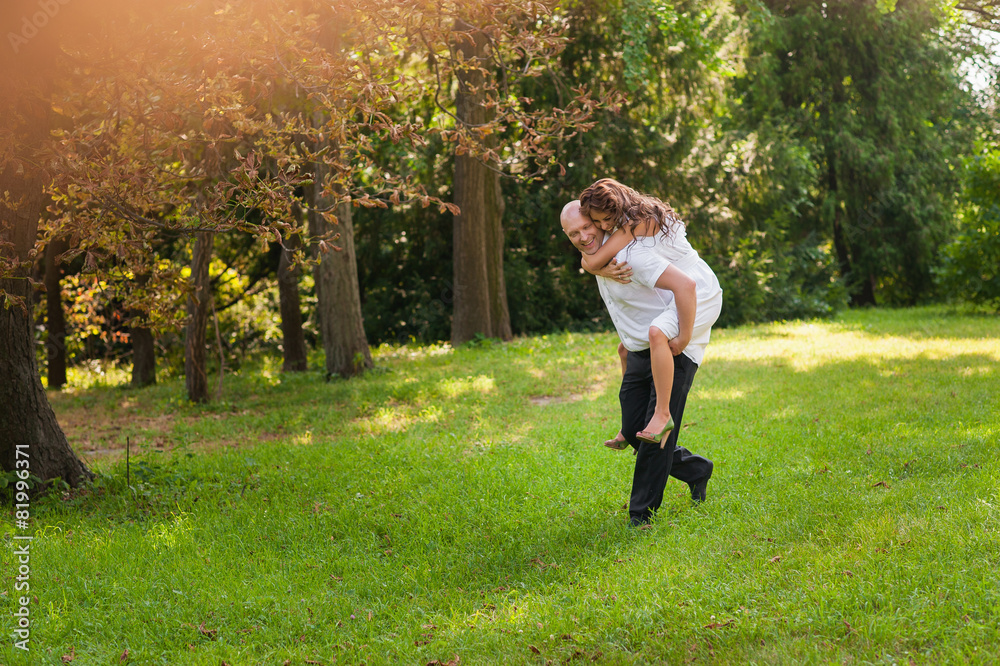 A man holding a happy girl in her arms