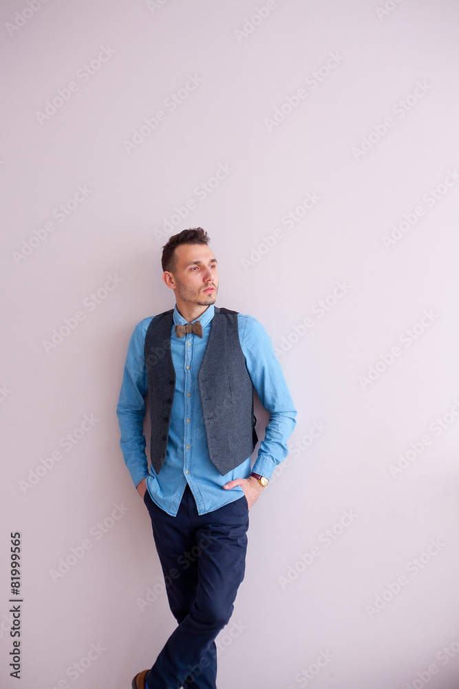 stylish attractive man standing by wall light stylish attractive man standing by wall light