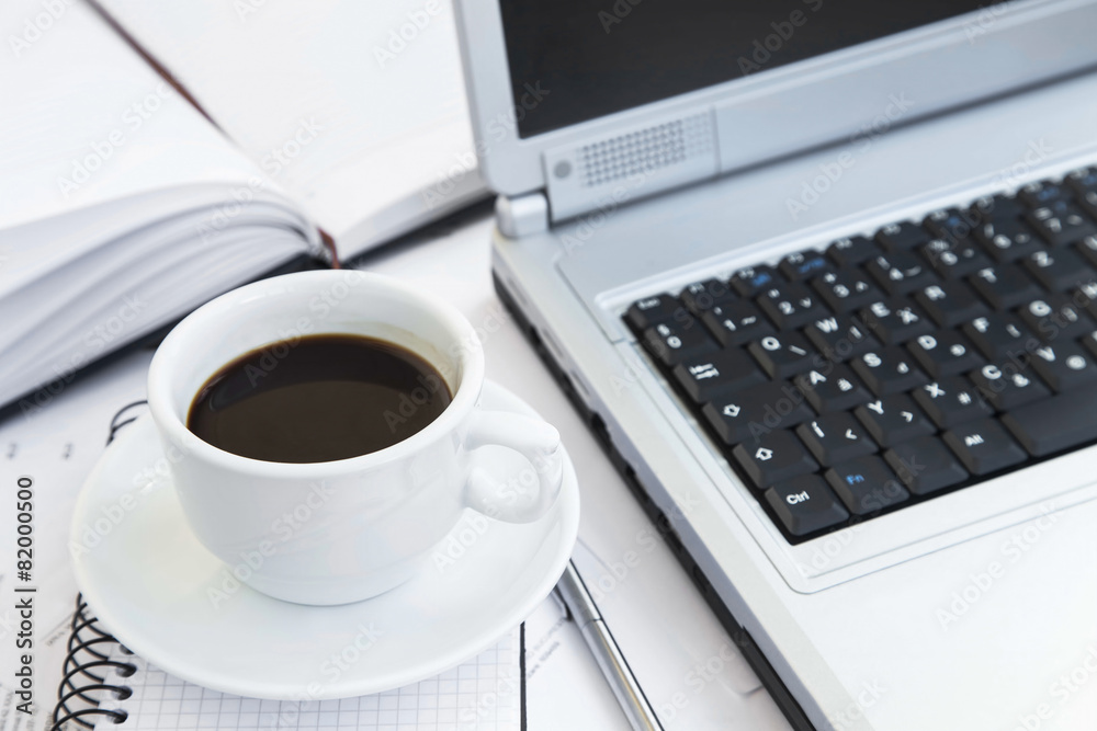 Coffee Cup at Office over Financial Papers,Computer and Agenda.C Coffee Cup at Office over Financial Papers,Computer and Agenda.C