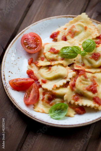 Italian square ravioli with tomato sauce and basil, close-up
