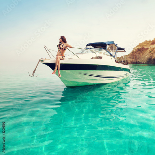 Beautiful young woman on boat. Luxury vacation at sea on yacht.