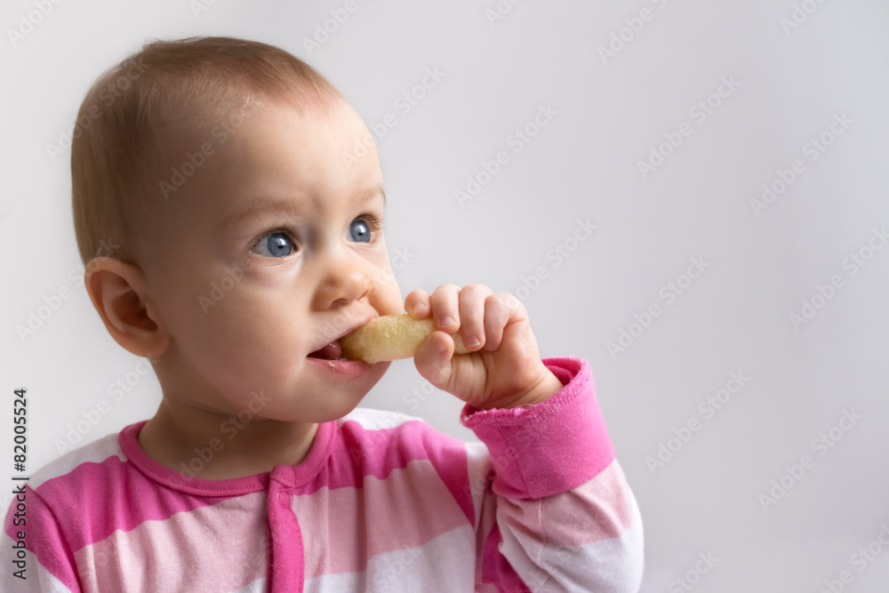 adorable baby girl eating a crunchy corn snack adorable baby girl eating a crunchy corn snack