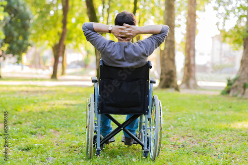 Man on a wheelchair relaxing in a park photo