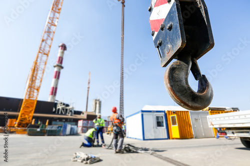 фотографія Crane hook with workers in the background
