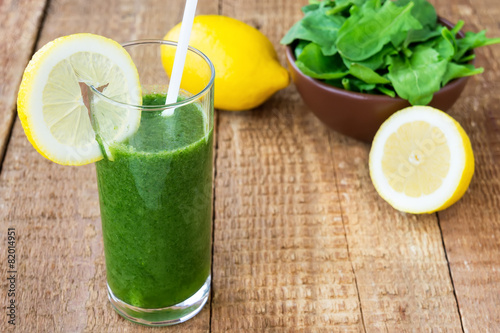 Healthy green smoothie with spinach and lemon on wooden backroun photo