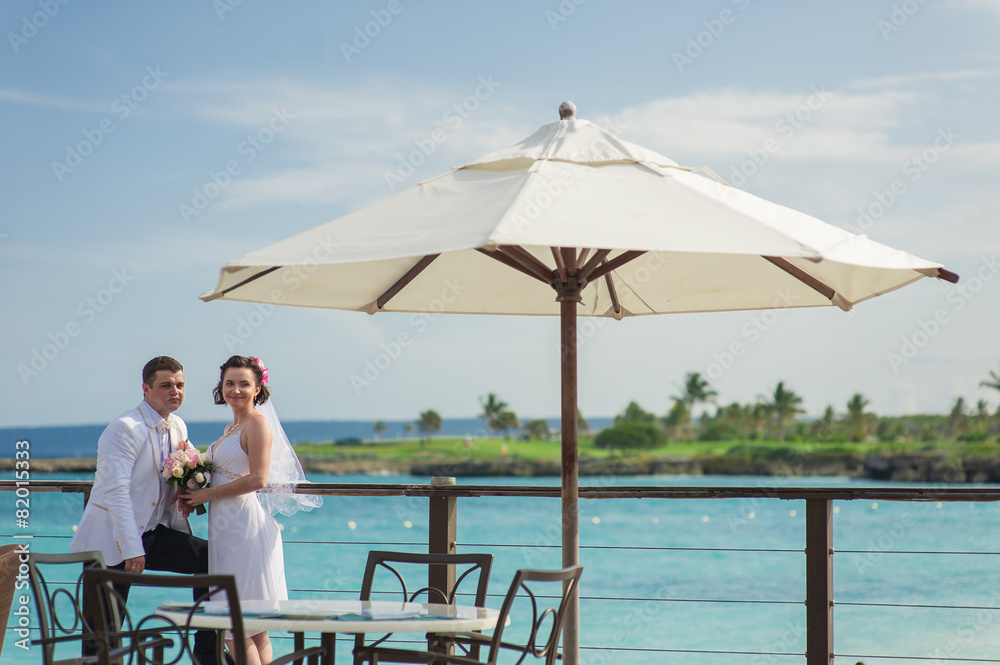 Young loving couple on tropical sea background - wedding at the