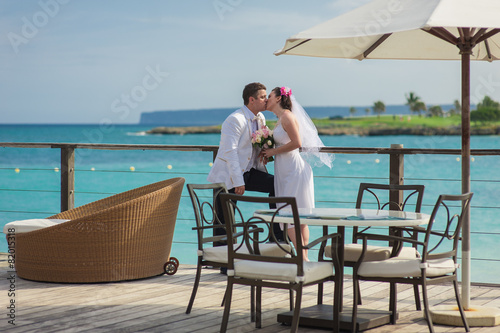 Young loving couple on tropical sea background - wedding at the