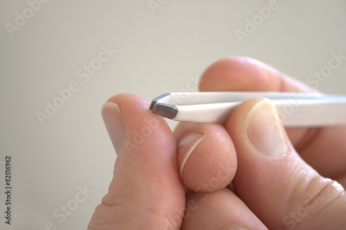 hand holding tweezers to pick a thorn