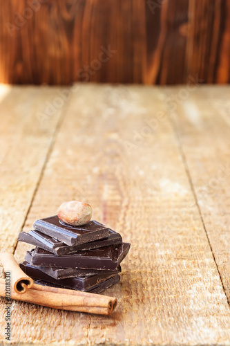 Stack of chocolate slices with nut and cinnamon on a wooden tabl