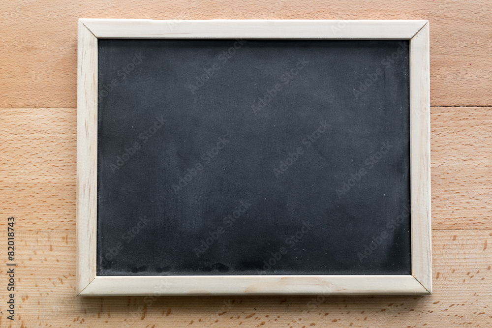 Horizontal shot of empty blackboard lying on wooden background Horizontal shot of empty blackboard lying on wooden background