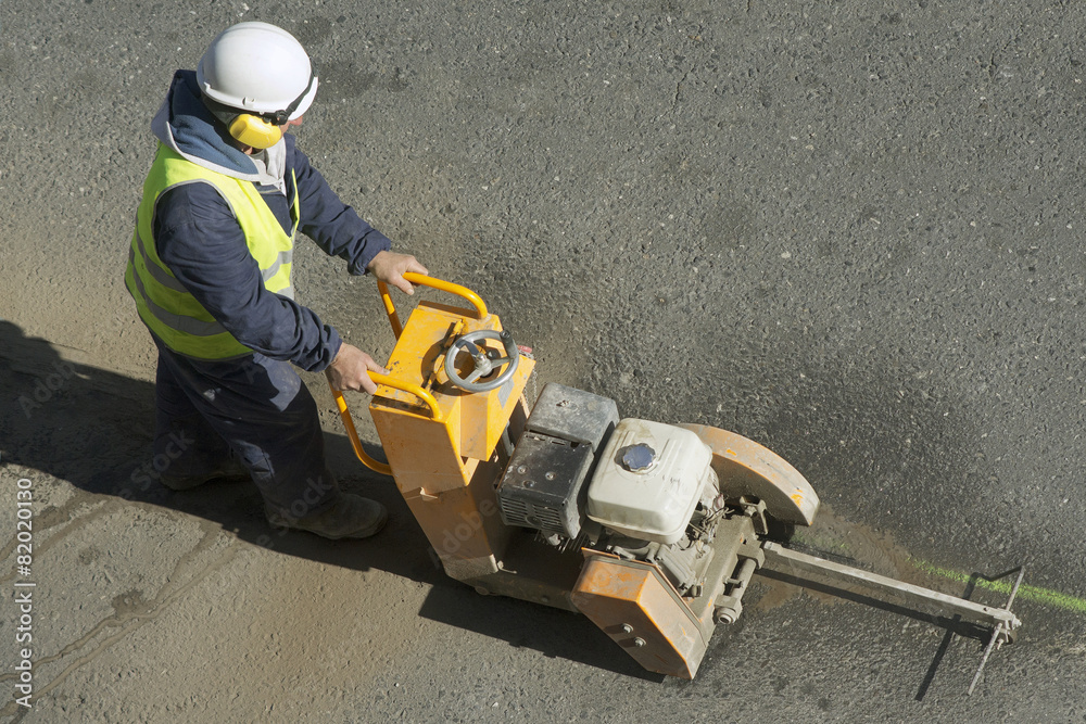 worker using cutting  pavement machine in the city road
