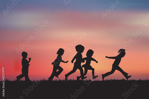 Silhouette, group of happy children playing on meadow, sunset, s