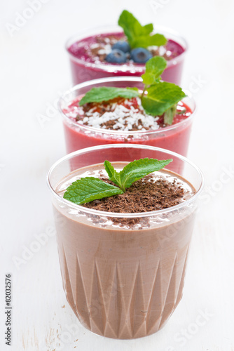chocolate, blueberry and strawberry milkshakes in glasses