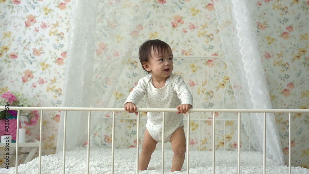 cute funny asian baby dancing on the bed