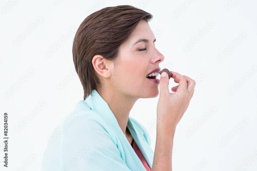Pretty brunette eating chocolate candy Pretty brunette eating chocolate candy