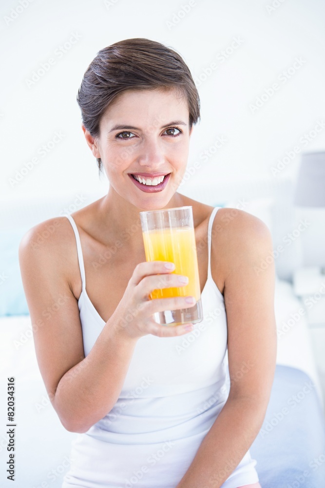 Happy woman taking drinking glass of orange juice Happy woman taking drinking glass of orange juice