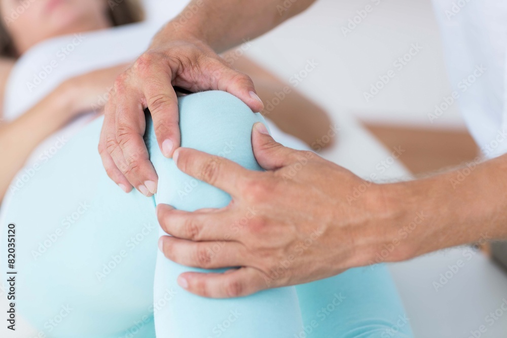 Physiotherapist doing leg massage to his patient Physiotherapist doing leg massage to his patient