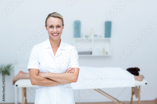 Physiotherapist smiling at camera arms crossed