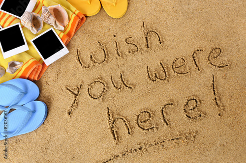 Canvas-taulu Wish you were here classic postcard or post card message written in sand on a tr