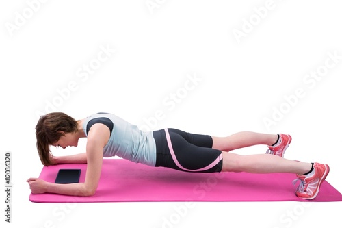 Pretty brunette doing plank on fitness mat