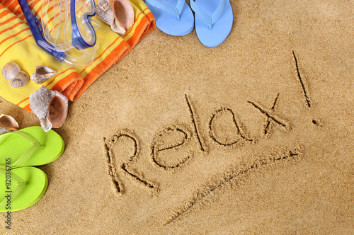 Relax word text message written in sand on a tropical beach with seashells and accessories summer holiday vacation relaxation photo
