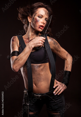 Attractive girl in sexy military uniform holding a knife