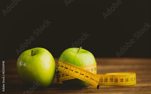 Green apples with measuring tape