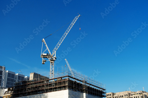 Gru che si erge sul cantiere tra i palazzi