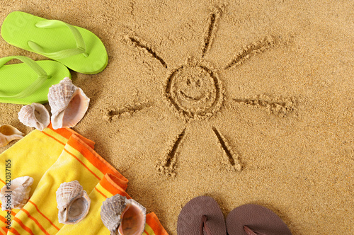 Smiling sun happy smiley face drawing drawn in sand on a tropical beach with seashells and accessories summer holiday vacation photo