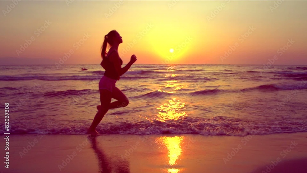 Beauty girl jogging along the sea coast over sunset Beauty girl jogging along the sea coast over sunset