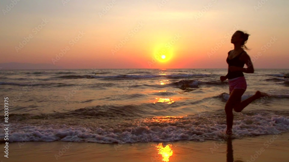 Young woman jogging along the sea coast over sunset Young woman jogging along the sea coast over sunset