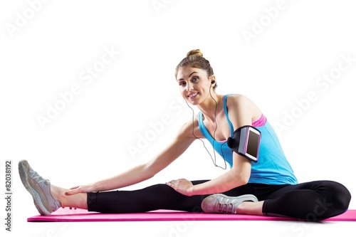 Fit woman stretching on exercise mat