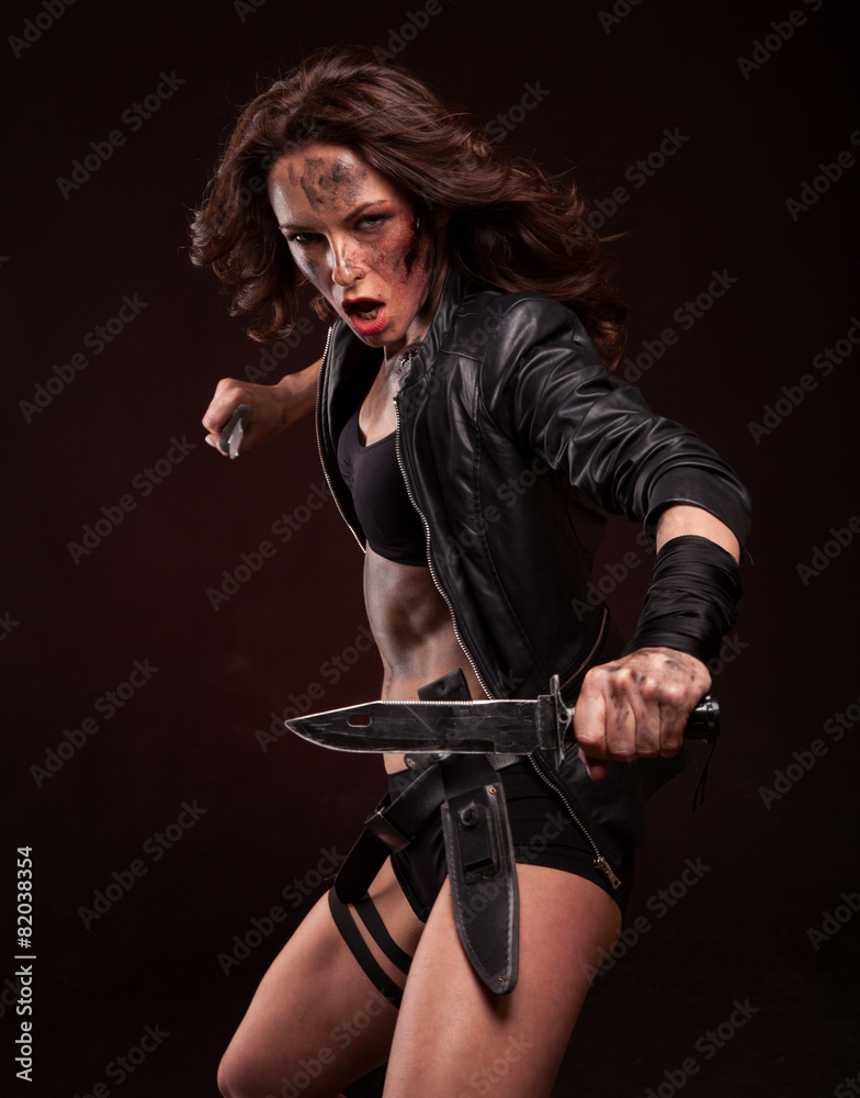 Fototapeta premium Attractive girl in sexy military uniform holding a knife