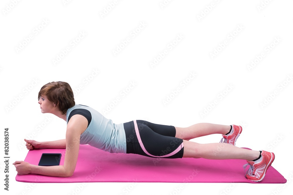 Pretty brunette doing plank on fitness mat