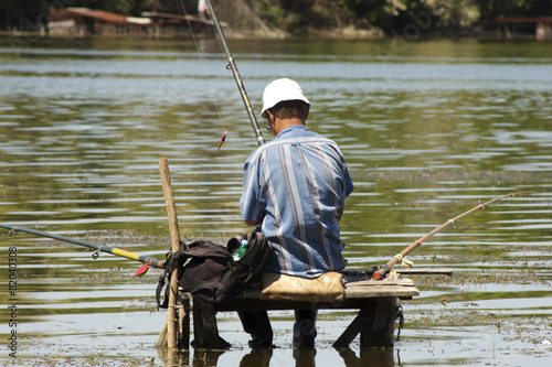 fisherman sitting on the bridge in the water