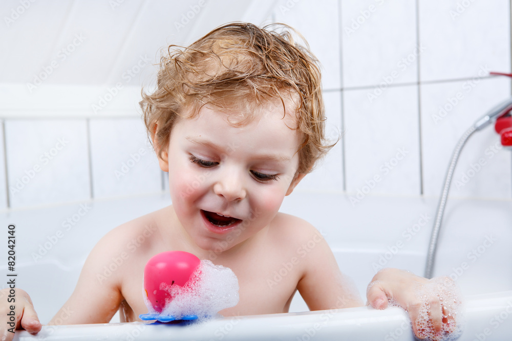 Adorable toddler boy having fun in bathtub Adorable toddler boy having fun in bathtub