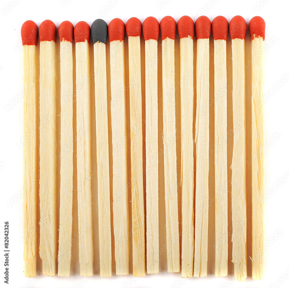 Close up of lined matches, one with a different color