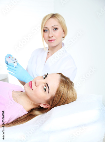 Cosmetologist applying perm...