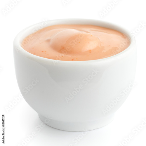 Small white ceramic dish of pink dressing. Isolated.