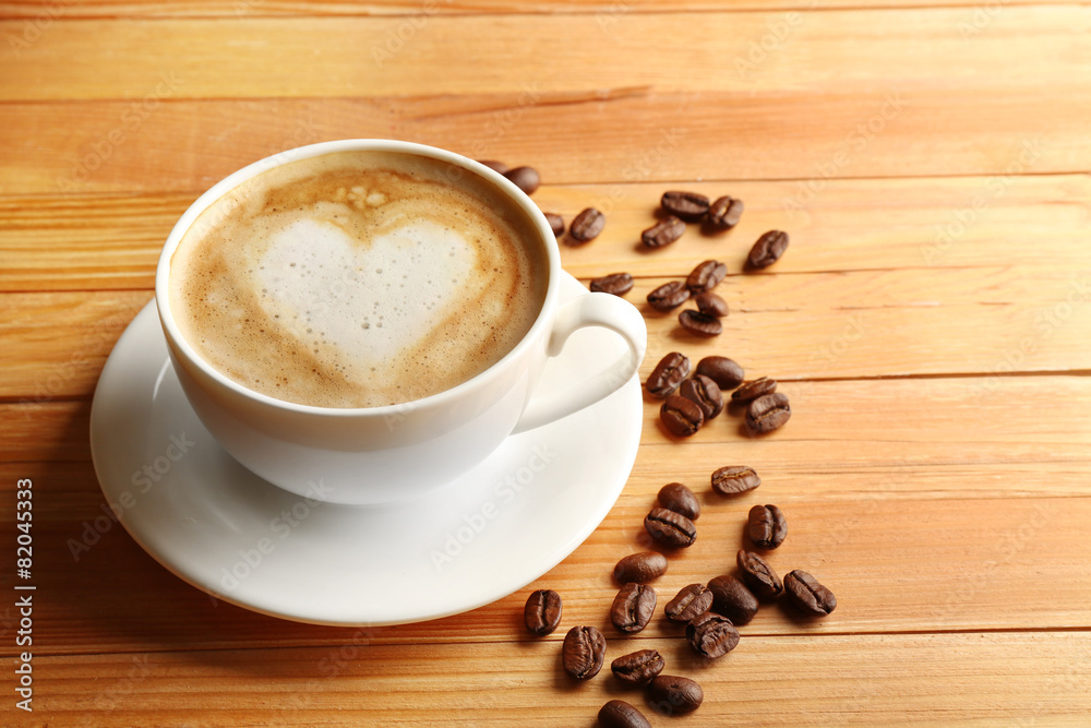 Cup of coffee latte art with grains on wooden background Cup of coffee latte art with grains on wooden background