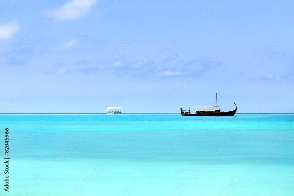 View of beautiful blue ocean water with boat in Baros Maldives