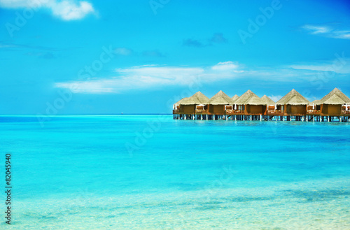 View of beautiful blue ocean water and bungalows in Baros © Africa Studio