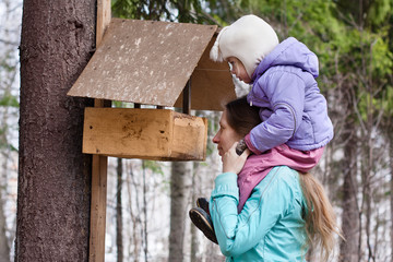 mother shows her daughter the bird feeder