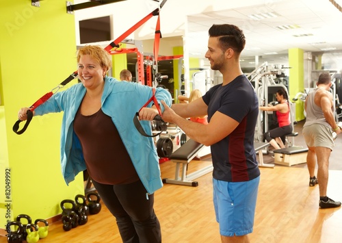 Overweight woman training with personal trainer