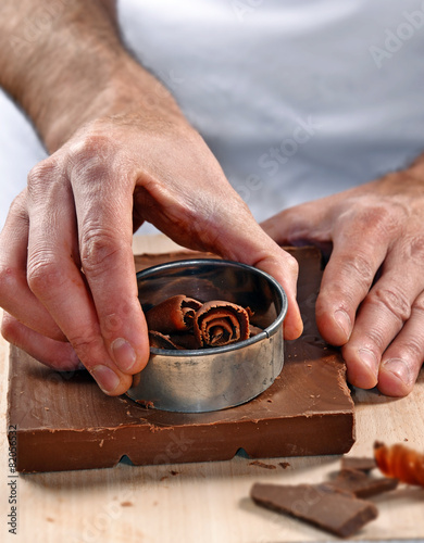 Cocinero preparando,cortando chocolate,cocinando con chocolate. photo