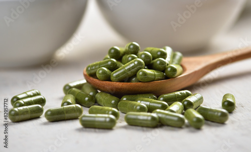 Moringa capsule pills in the woodspoon photo