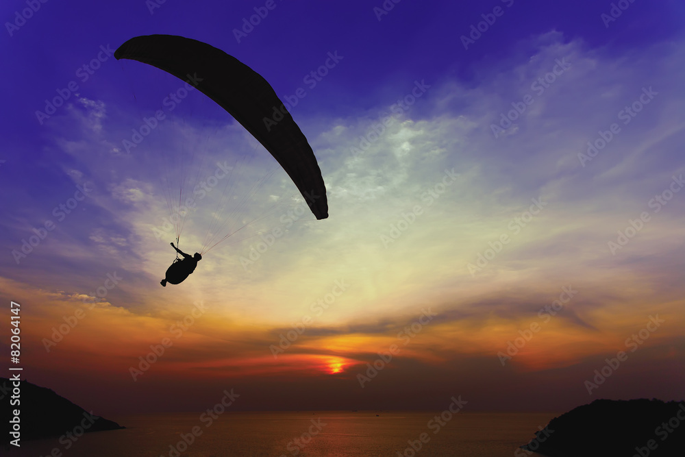 Paraglider silhouette against the background of the sunset sky Paraglider silhouette against the background of the sunset sky