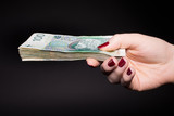 Polskie pieniądze w kobiecej dłoni - banknoty